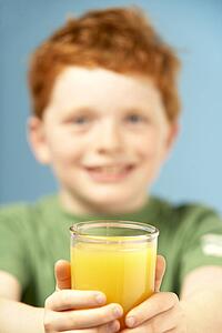 Young Boy Holding Glass Of Juice