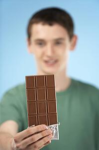 Teenage Boy Holding Bar Of Chocolate