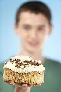 Teenage Boy Holding Cream Cake