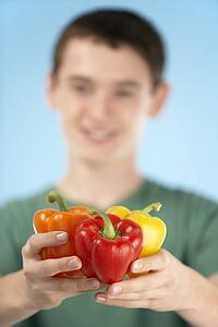 Teenage Boy Holding Fresh Peppers