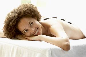 Young Woman Enjoying Hot Stone Treatment
