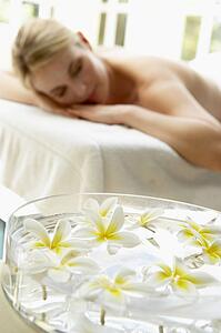 Woman On Massage Table With Flowers In Foreground