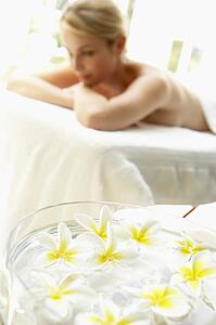 Woman On Massage Table With Flowers In Foreground