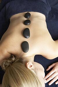 Young Woman Enjoying Hot Stone Treatment
