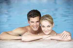 Young Couple Swimming In Pool