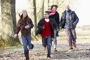 Family Running Through Autumn Countryside