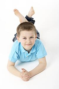 Young Boy Lying On Stomach In Studio