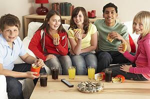 Group Of Children Eating Burgers At Home