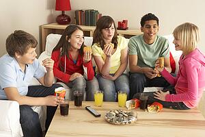 Group Of Children Eating Burgers At Home
