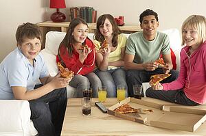 Group Of Children Eating Pizza At Home