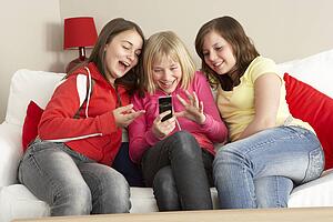 Group Of Three Girls Reading Text Message