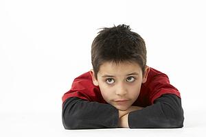 Young Boy Lying On Stomach In Studio