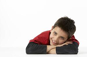 Young Boy Lying On Stomach In Studio