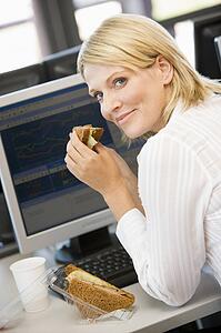 Businesswoman Enjoying Sandwich During Lunchbreak