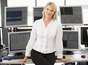 Portrait Of Stock Trader In Front Of Computer Monitors