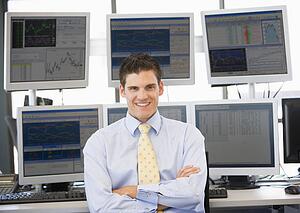 Portrait Of Stock Trader In Front Of Computer Monitors