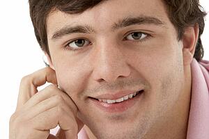 Studio Portrait Of Smiling Teenage Boy