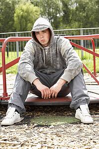 Young Man Sitting In Playground