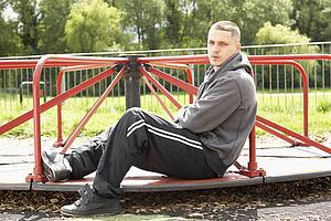 Young Man Sitting In Playground