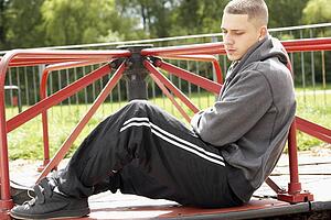 Young Man Sitting In Playground