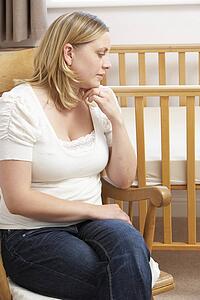 Sad Mother Sitting In Empty Nursery