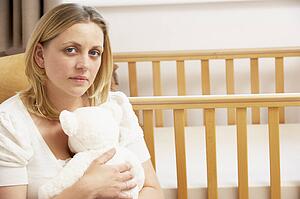 Sad Mother Sitting In Empty Nursery