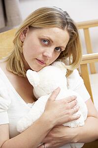 Sad Mother Sitting In Empty Nursery