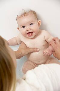 Mother Bathing Baby At Home