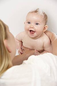 Mother Bathing Baby At Home