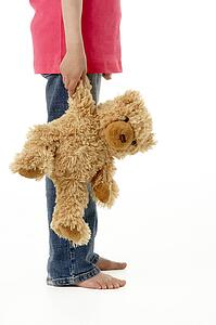 Studio Portrait of Girl Standing with Teddy Bear