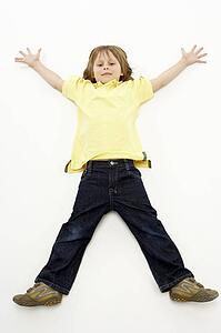Studio Portrait of Smiling Boy lying down with arms and legs spread