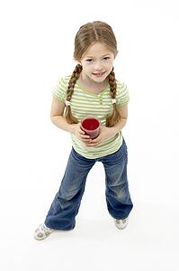 Studio Portrait of Smiling Girl Holding Glass of Juice