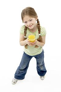 Studio Portrait of Smiling Girl Holding Orange Juice