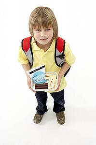 Studio Portrait of Smiling Boy Holding Lunchbox