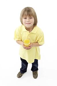 Studio Portrait of Smiling Boy Holding Glass of Fruit Juice