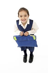 Studio Portrait of Smiling Girl Holding School Bag
