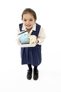 Studio Portrait of Smiling Girl Holding Lunchbox