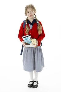 Studio Portrait of Smiling Girl Holding Lunchbox