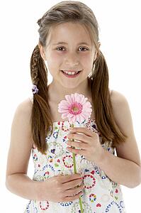 Studio Portrait of Smiling Girl Holding Flower