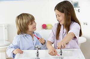 Siblings Brushing Teeth Together at Sink
