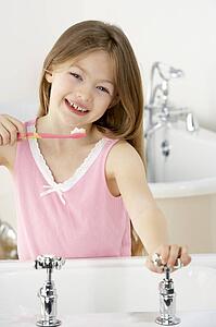 Young Girl Brushing Teeth at Sink