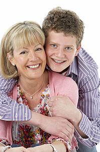 Studio Portrait of Smiling Teenage Boy with Mum