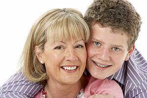 Studio Portrait of Smiling Teenage Boy with Mum