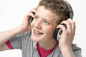 Portrait of Smiling Teenage Boy Listening to Music