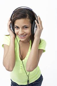 Portrait of Smiling Teenage Girl Listening to Music