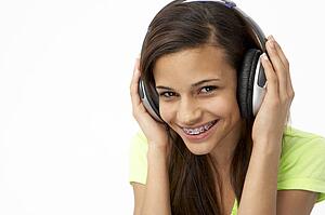 Portrait of Smiling Teenage Girl Listening to Music