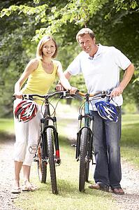 Couple riding bikes in countryside