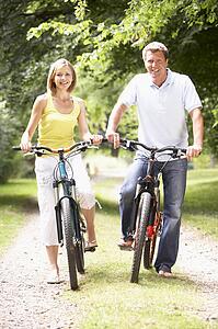 Couple riding bikes in countryside