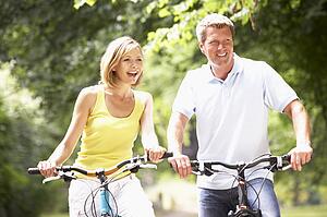 Couple riding bikes in countryside