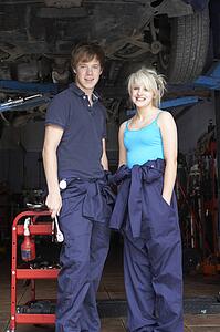 Mechanic and apprentice working on car
